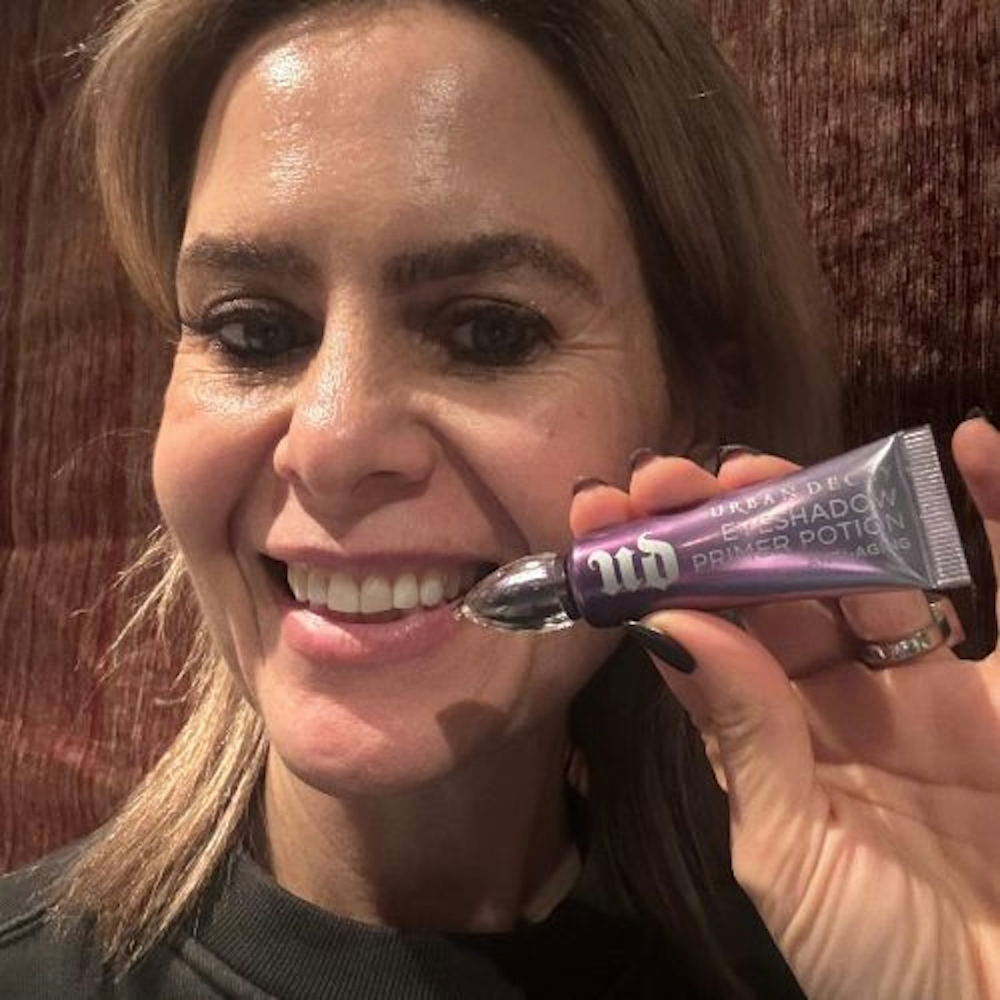 Suzanne holding Urban Decay Eyeshadow Primer Potion Anti-Aging