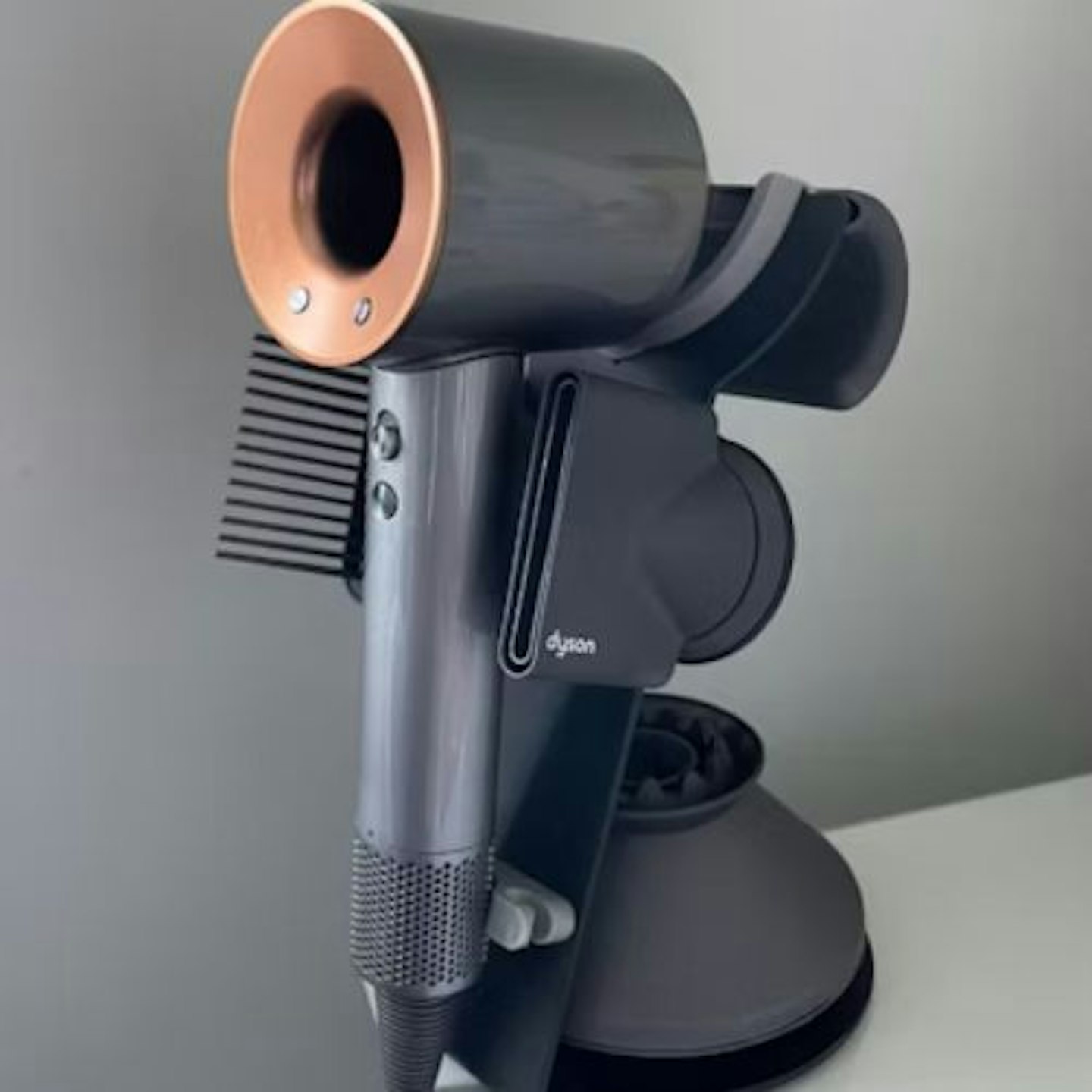 side view of the Dyson Supersonic™ Hair Dryer on its stand with attachments