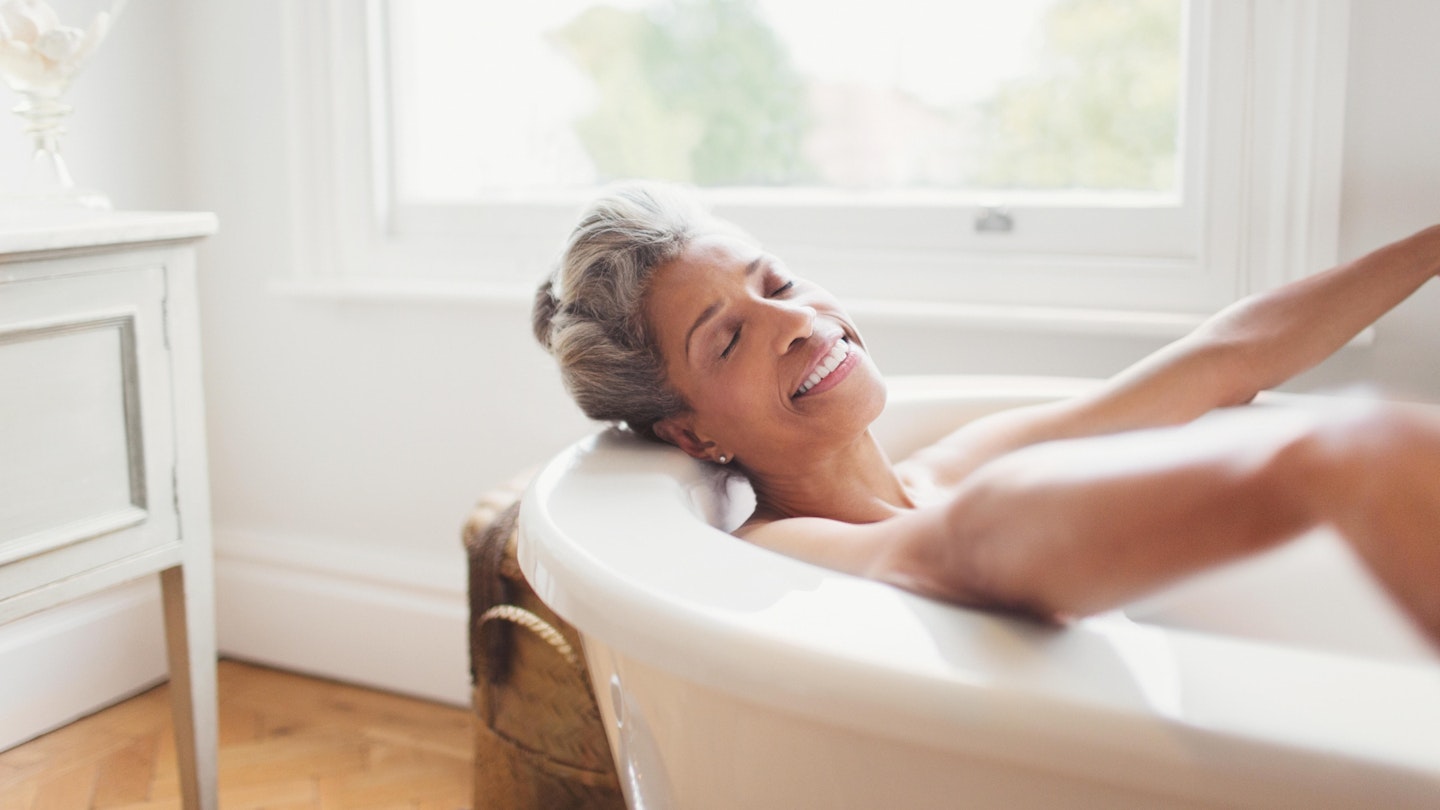 Mature woman with eyes closed enjoying bath