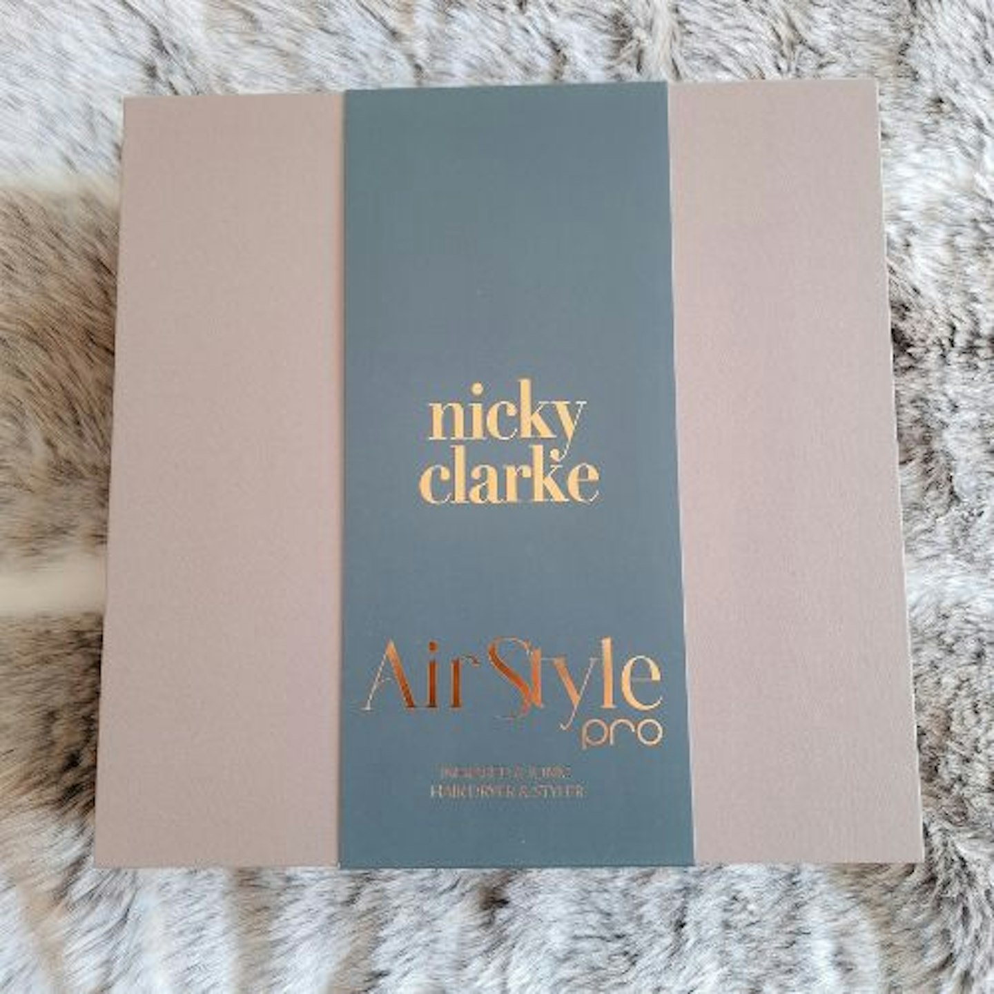 photo of the premium box the Nicky Clarke AirStyle Pro Infrared & Ionic Hair Dryer & Styler comes in on a faux fur throw