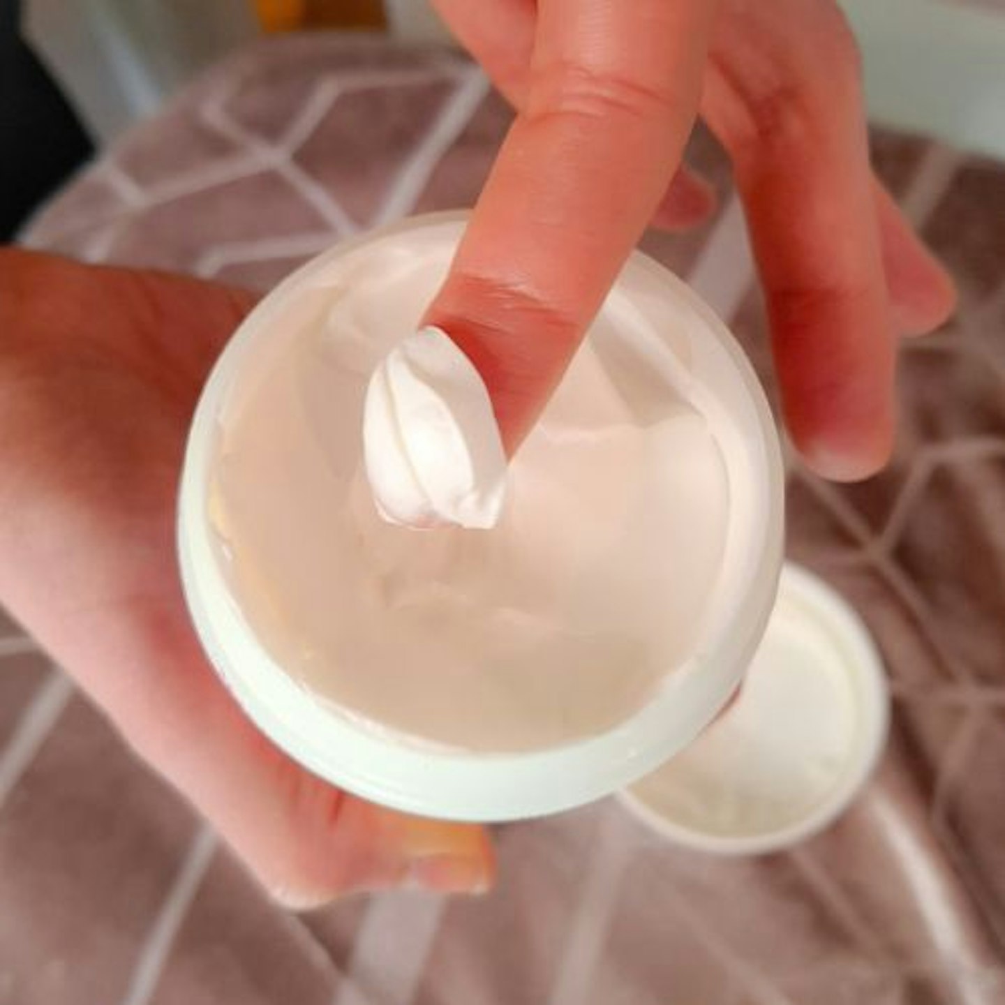 top view close up of a pot of Philip Kingsley Extreme Elasticizer showing the styling cream in the pot and on the tester's finger