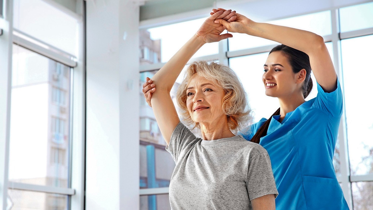 Physiotherapist working with elderly patient in clinic