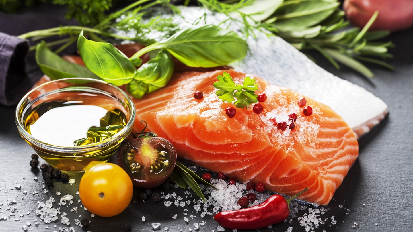 Portion of fresh salmon fillet with aromatic herbs, spices and vegetables