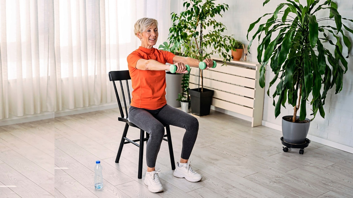 Senior woman doing chair exercises with dumbbells