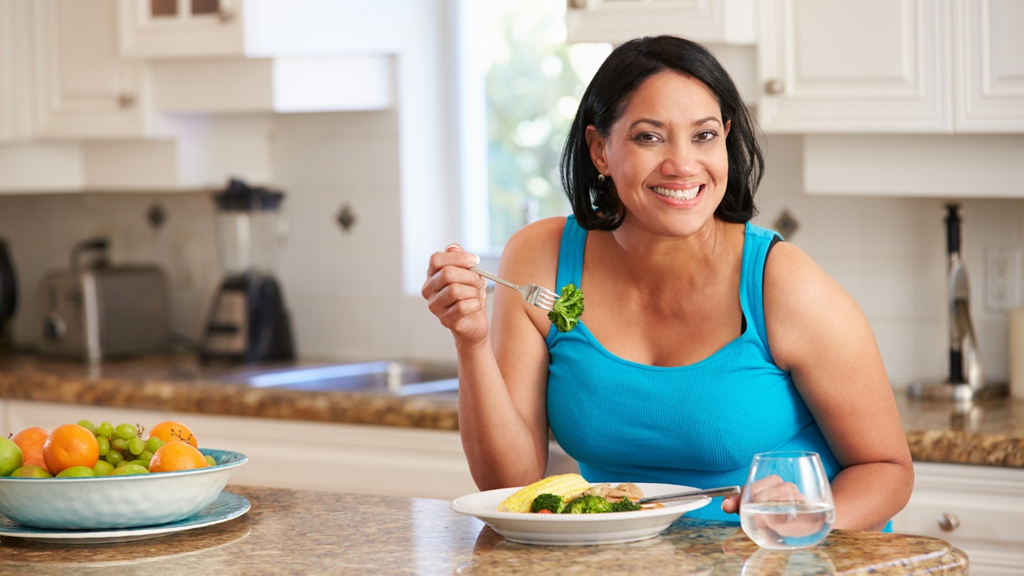 Woman Eating Healthy Meal in Kitchen