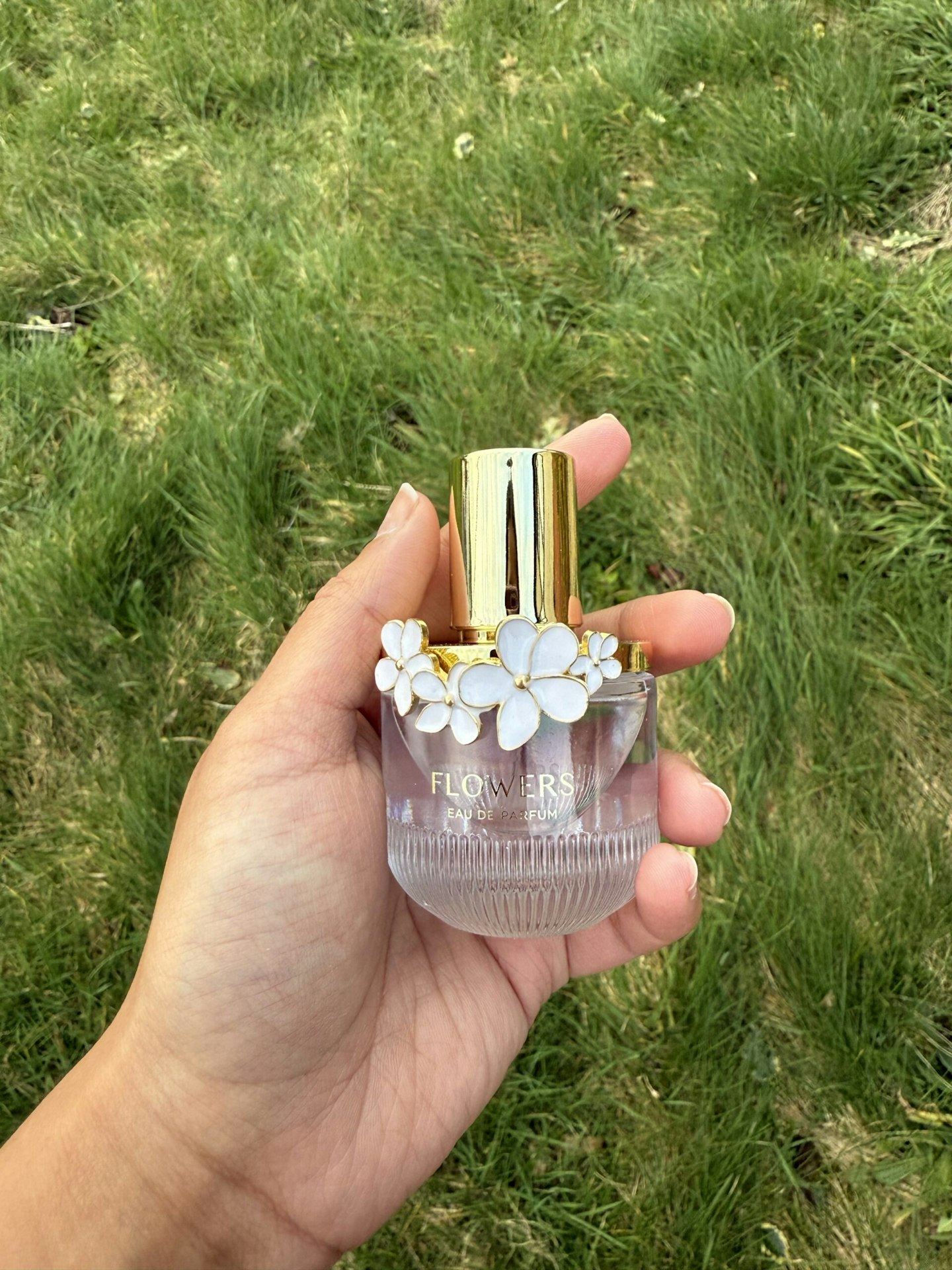 Tester holding the Flowers Perfume