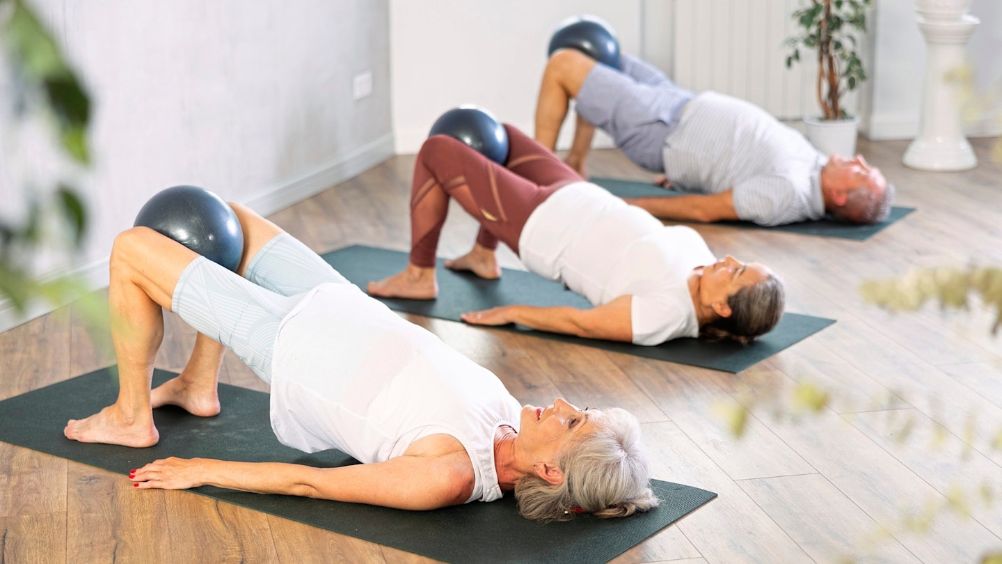 Three people exercising on yoga mats