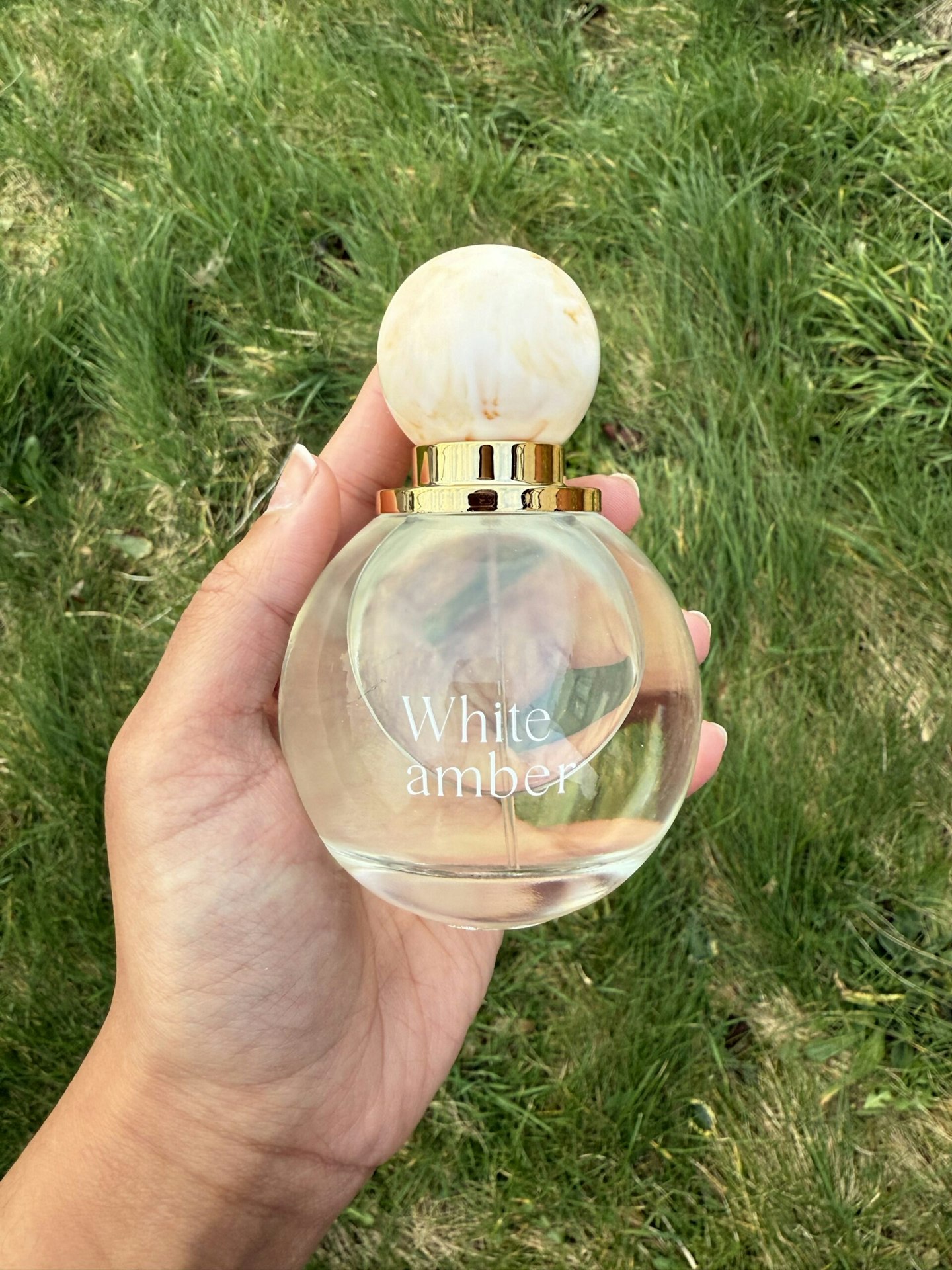 Tester holding the White Amber Perfume 