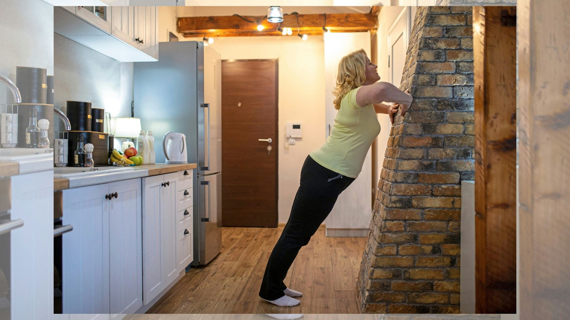 Mature woman doing standing wall push-ups