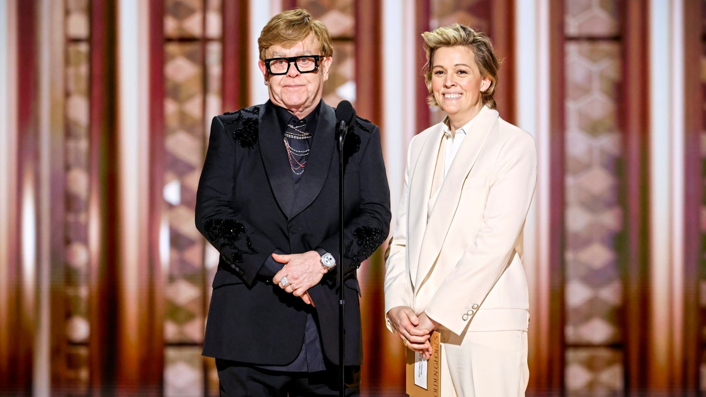 Elton John and Brandi Carlile speaking onstage at the 82nd Annual Golden Globe Awards