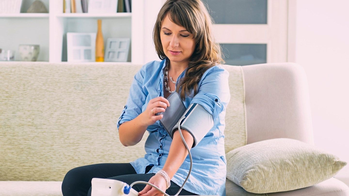 Woman checking her blood pressure at home