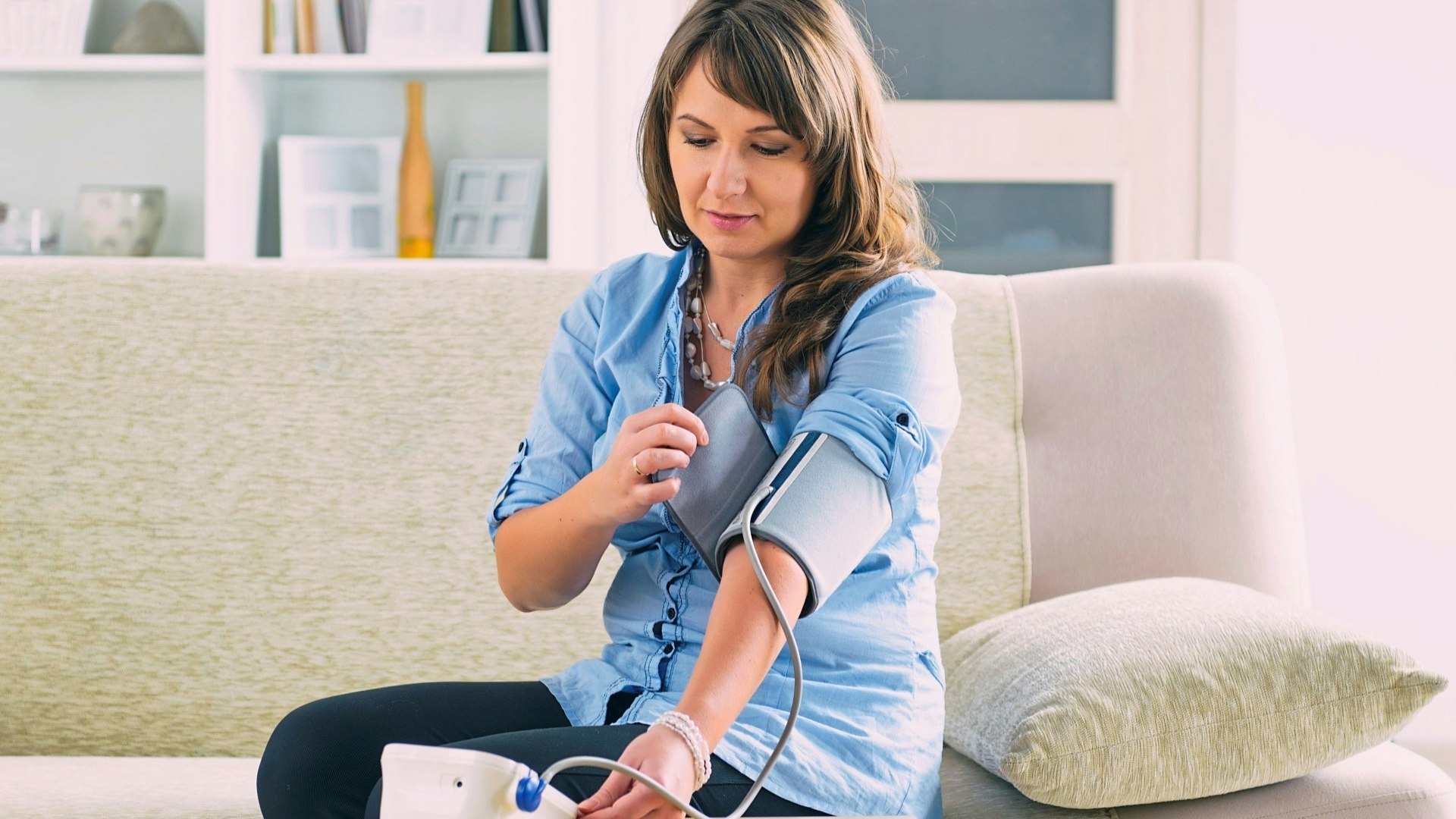 Woman checking her blood pressure at home