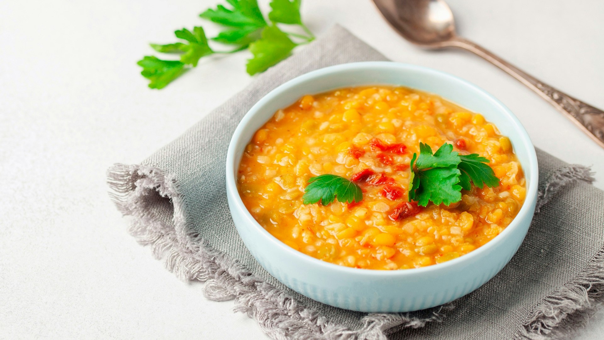 Homemade peas lentil soup with pepper and parsley in bowl on a table
