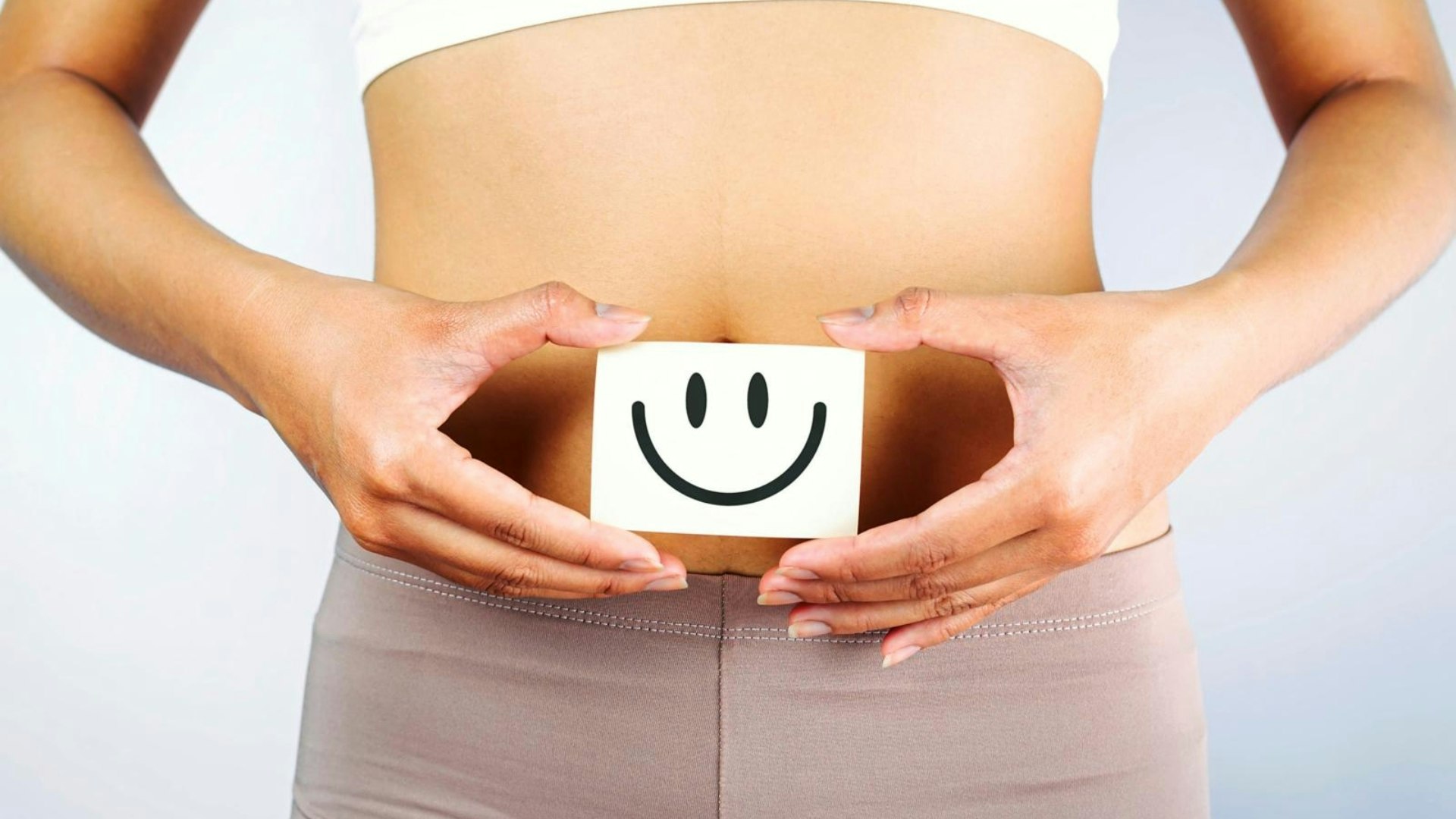 A lady holding a smiley face to her stomach