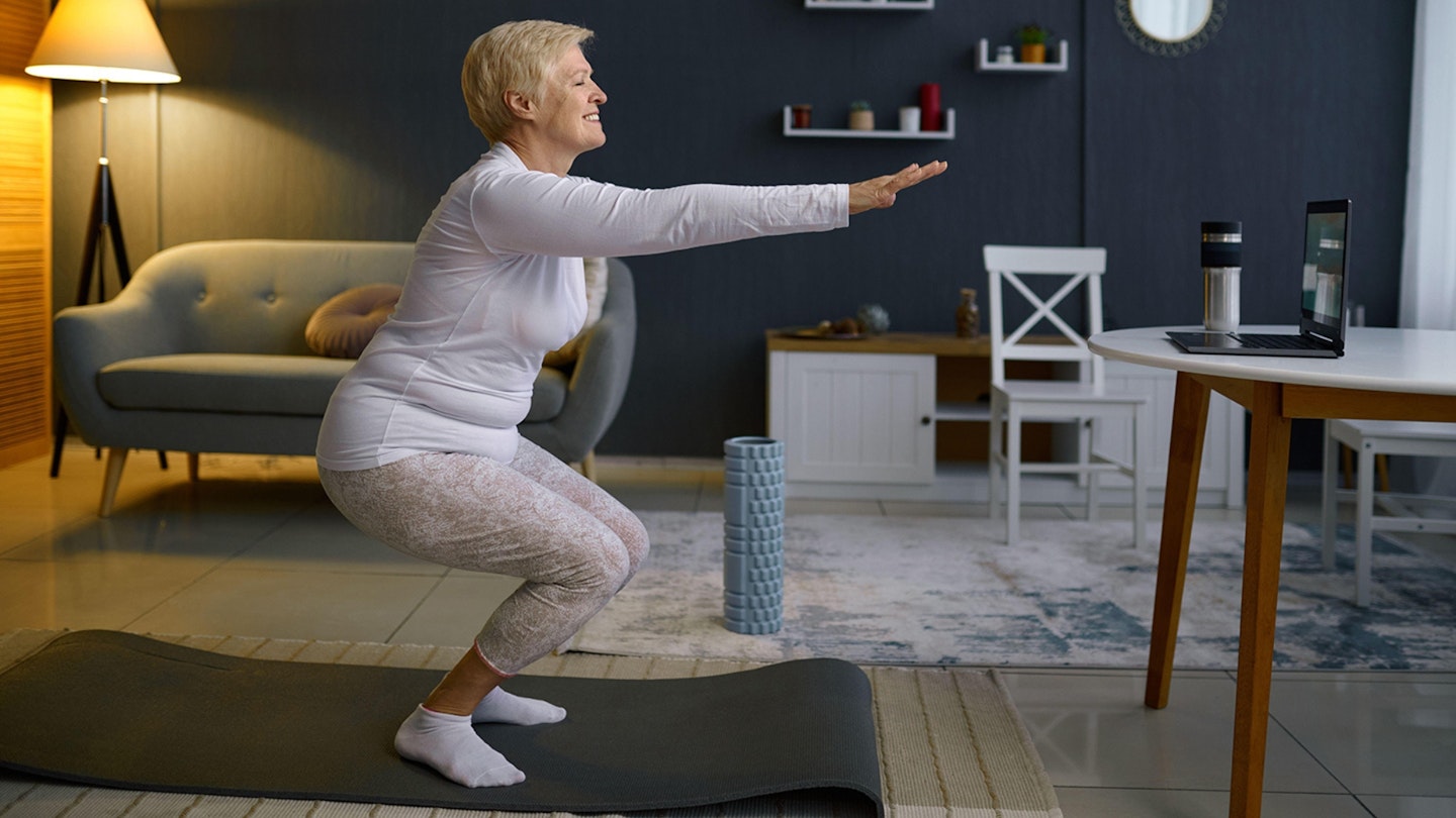 Senior woman doing squats exercising at home