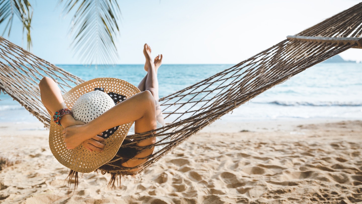 Woman relaxing in a hammock on beach