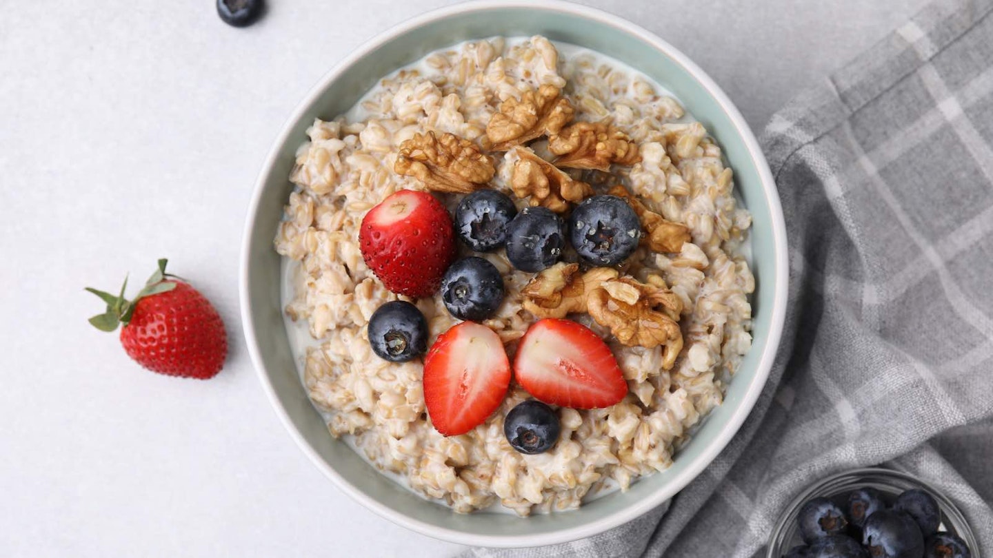 Bowl of porridge with strawberries, blueberries and walnuts