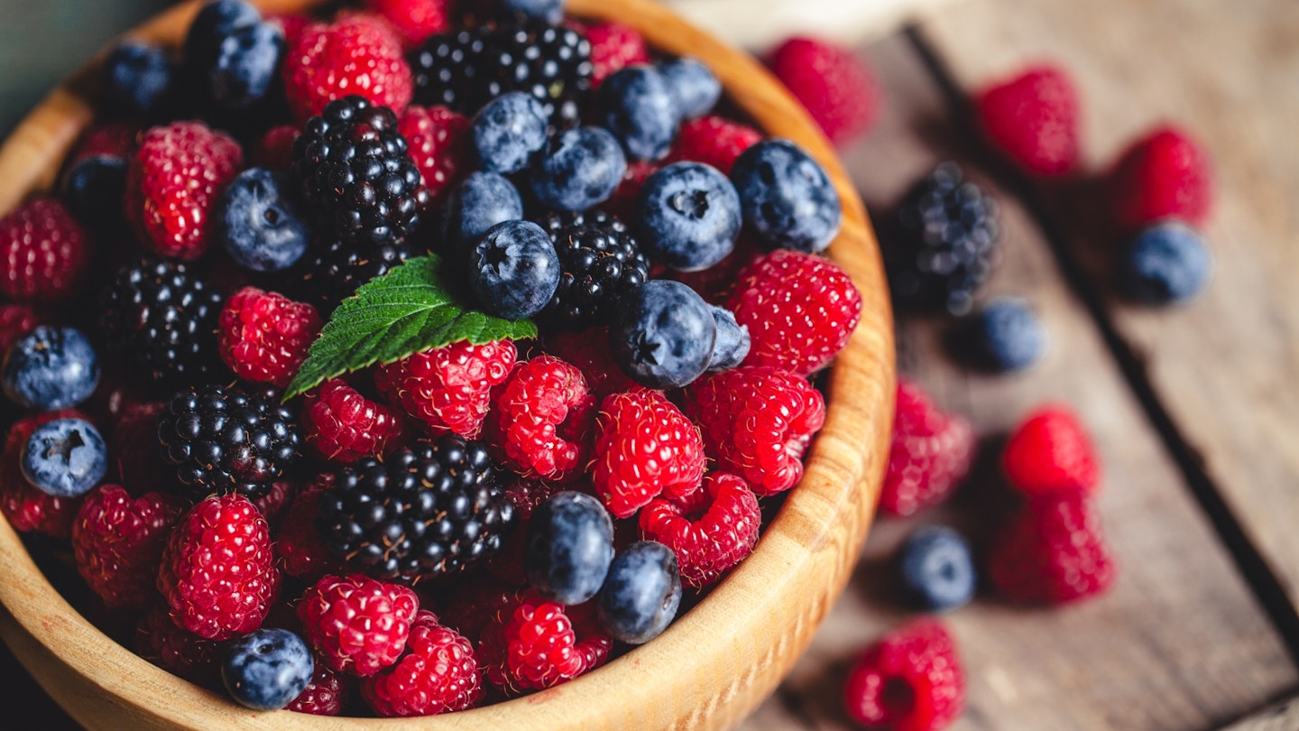 blueberries and raspberries, blackberry in a wooden bowl