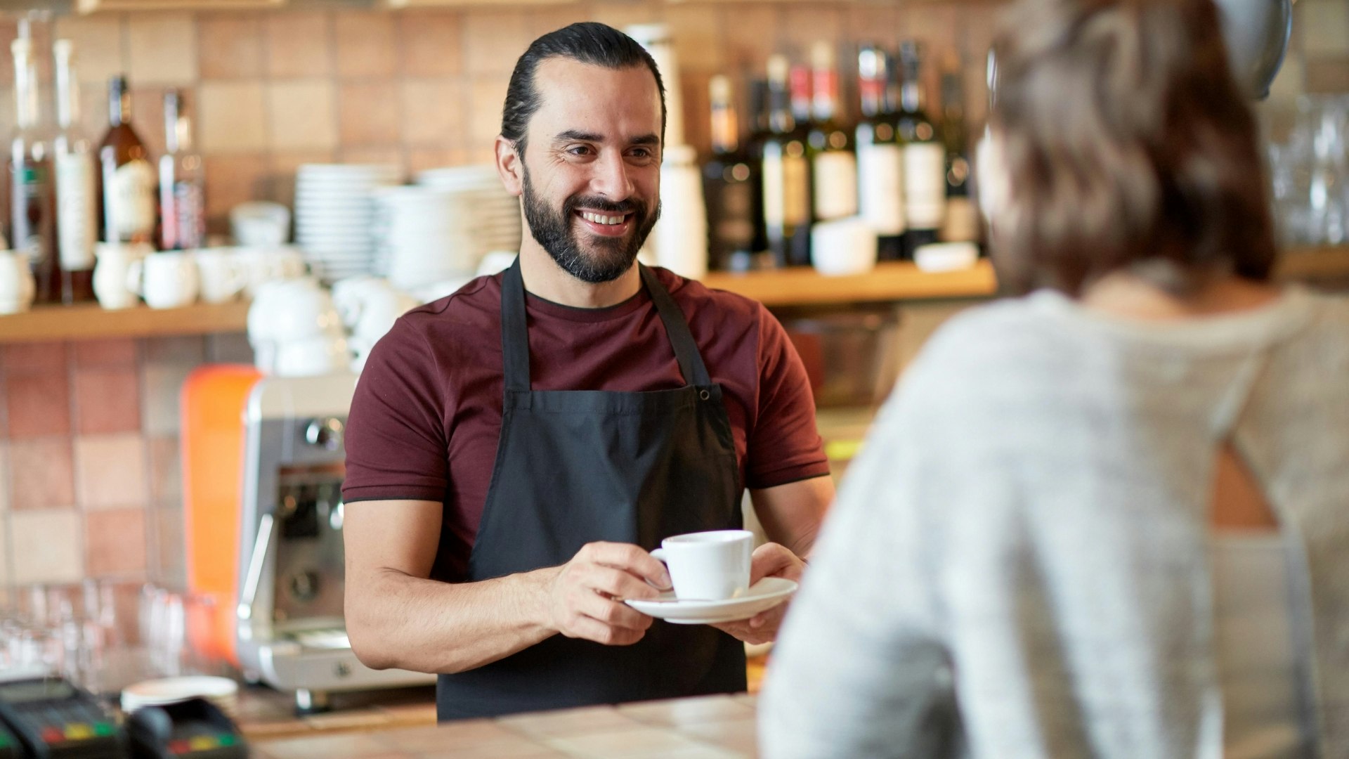 man or waiter serving customer in coffee shop