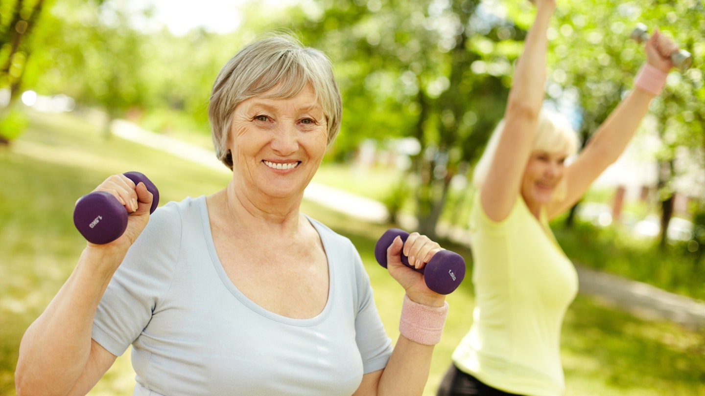 Active mature woman exercising with dumbbells in her hand