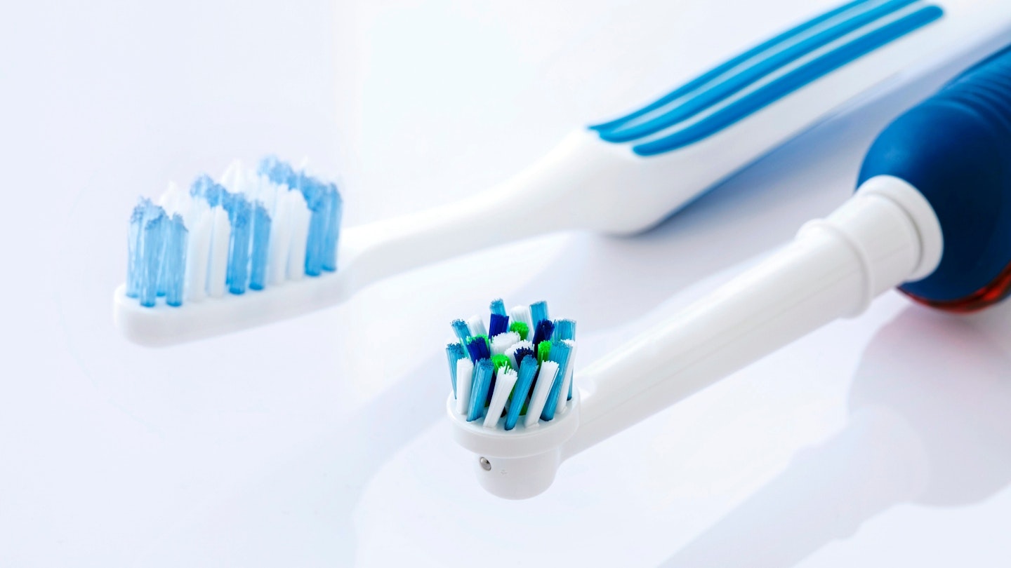 Electric and manual toothbrushes against a white background.