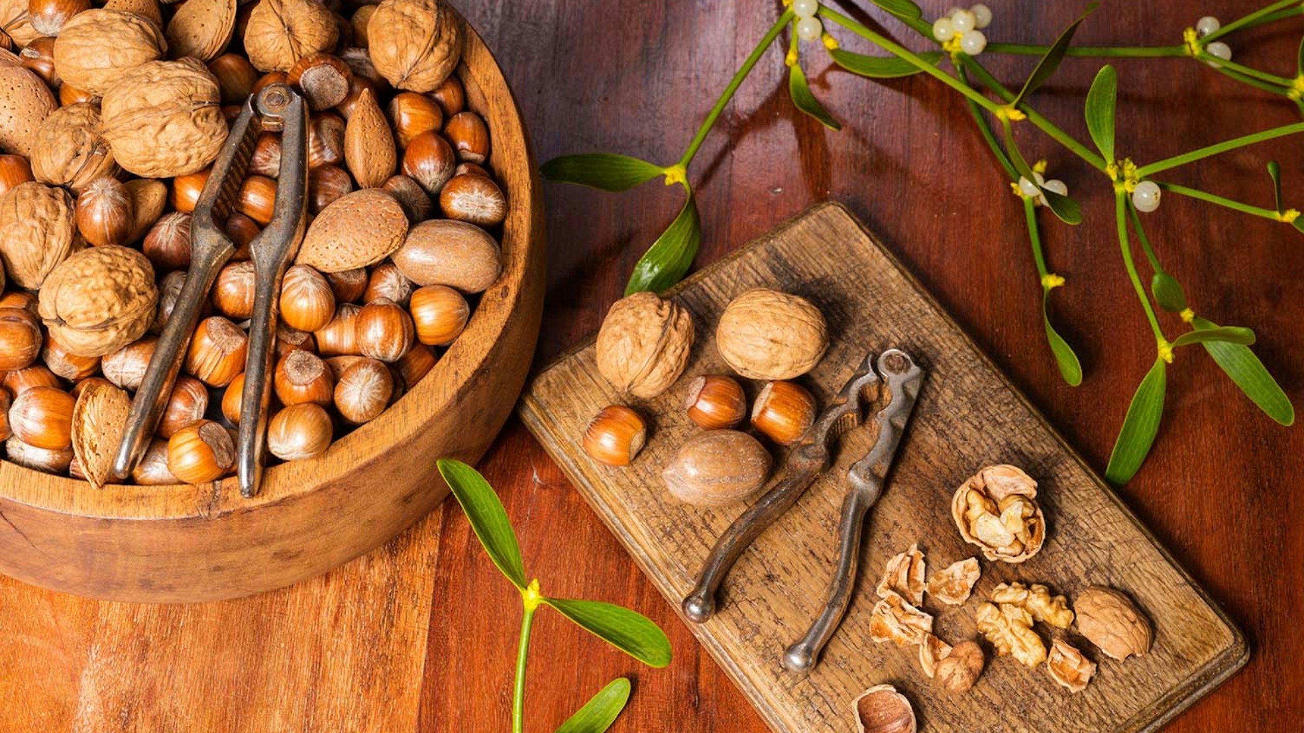 Edible nuts and nutcrackers on a table at home with mistletoe in a christmas setting