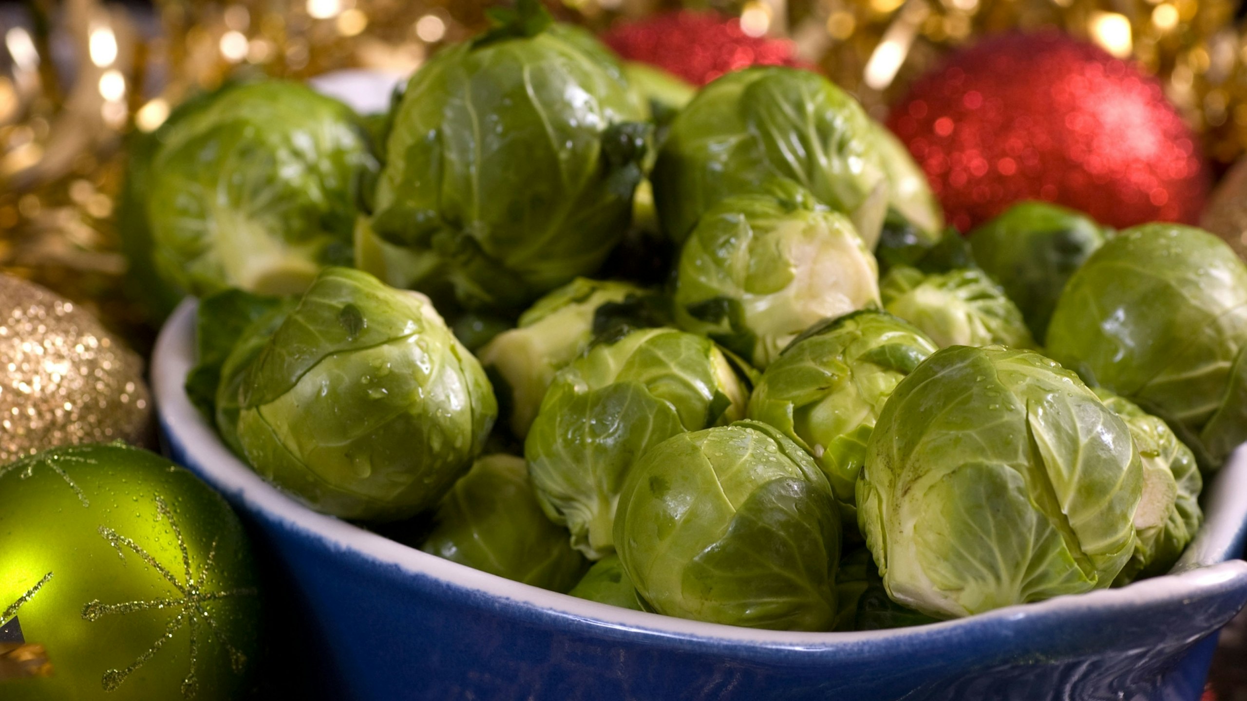 Brussel Sprouts with lemon juice and herbs set in a Christmas setting with ball balls and tinsel