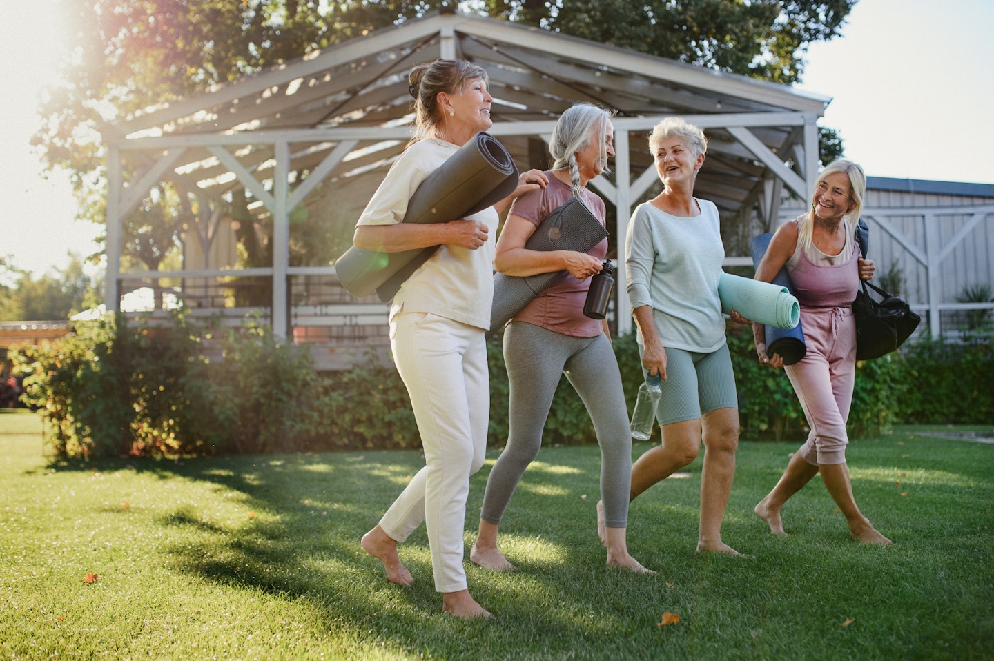 Cheerful group of senior women talking after exercise outdoors in park
