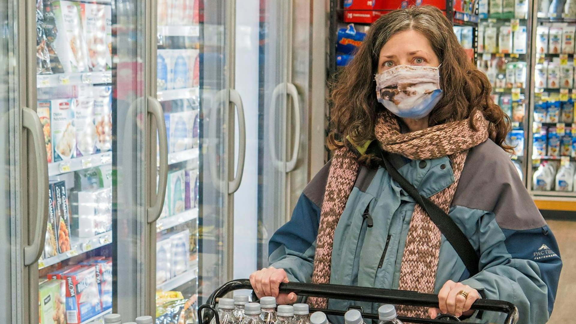 Woman wearing face mask while grocery shopping during COVID-19 pandemic