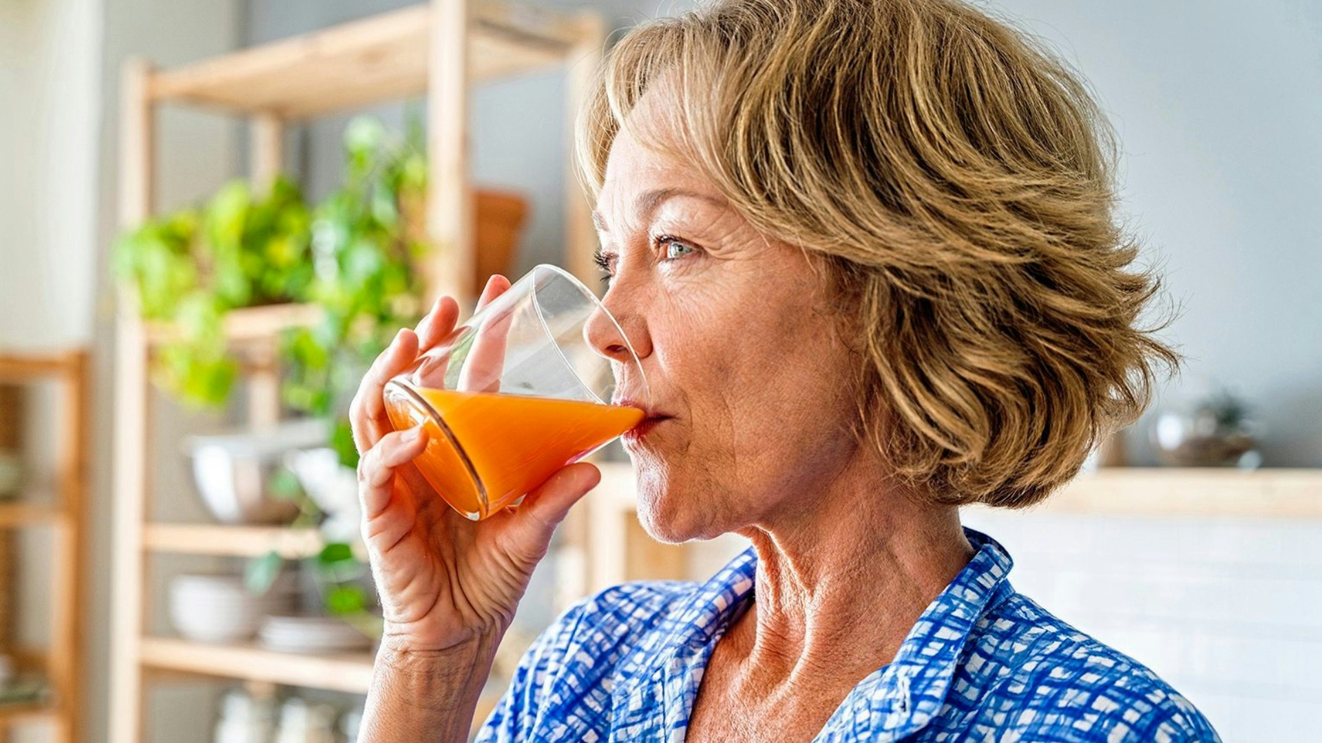 female adult drinking healthy orange juice for breakfast