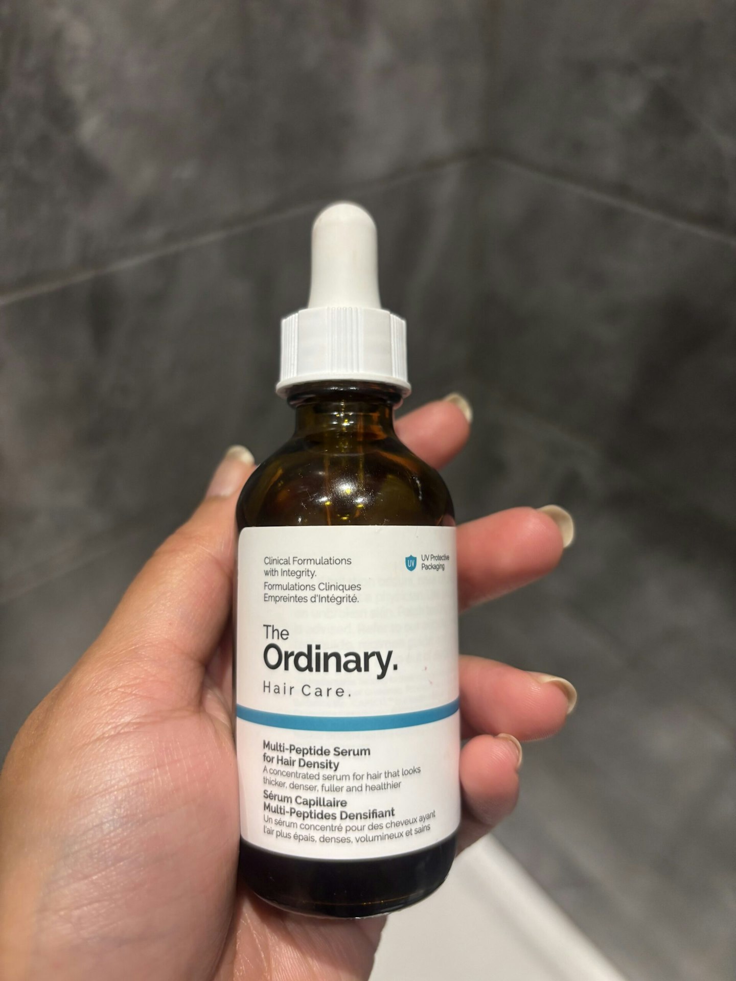 Tester holding the The Ordinary Multi-Peptide Serum for Hair Density