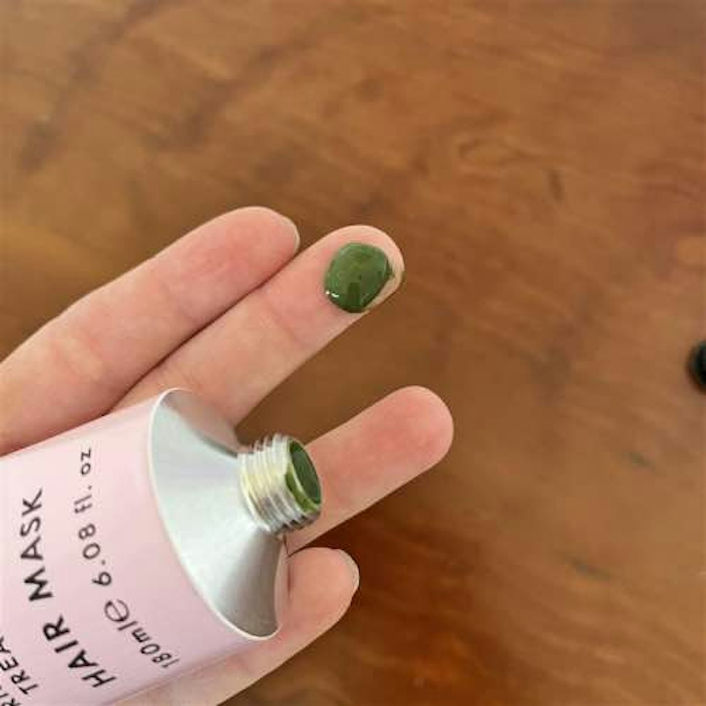 Hair gain hair mask tube plus green hair mask contents on finger 