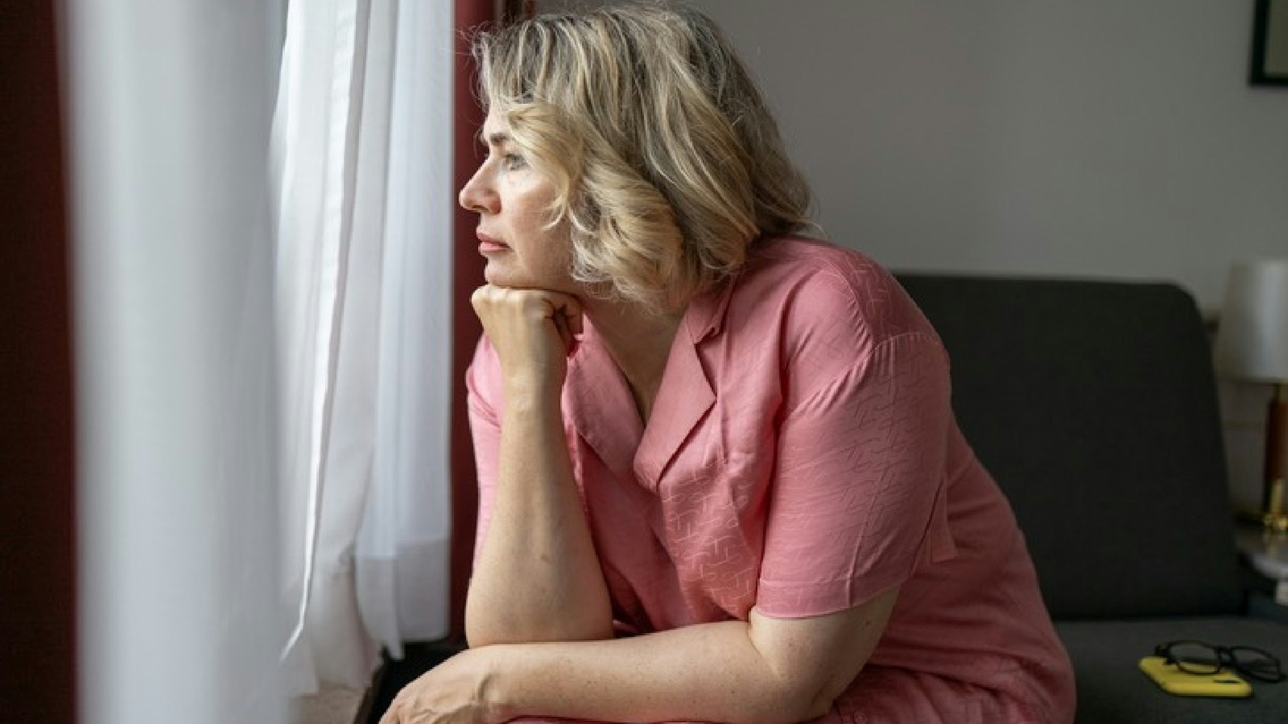 woman in pink pyjamas looking sad