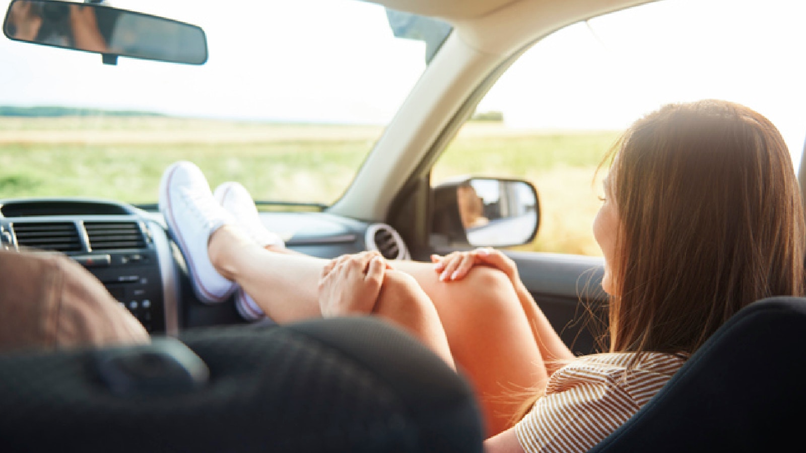 woman with feet on dashboard of a car
