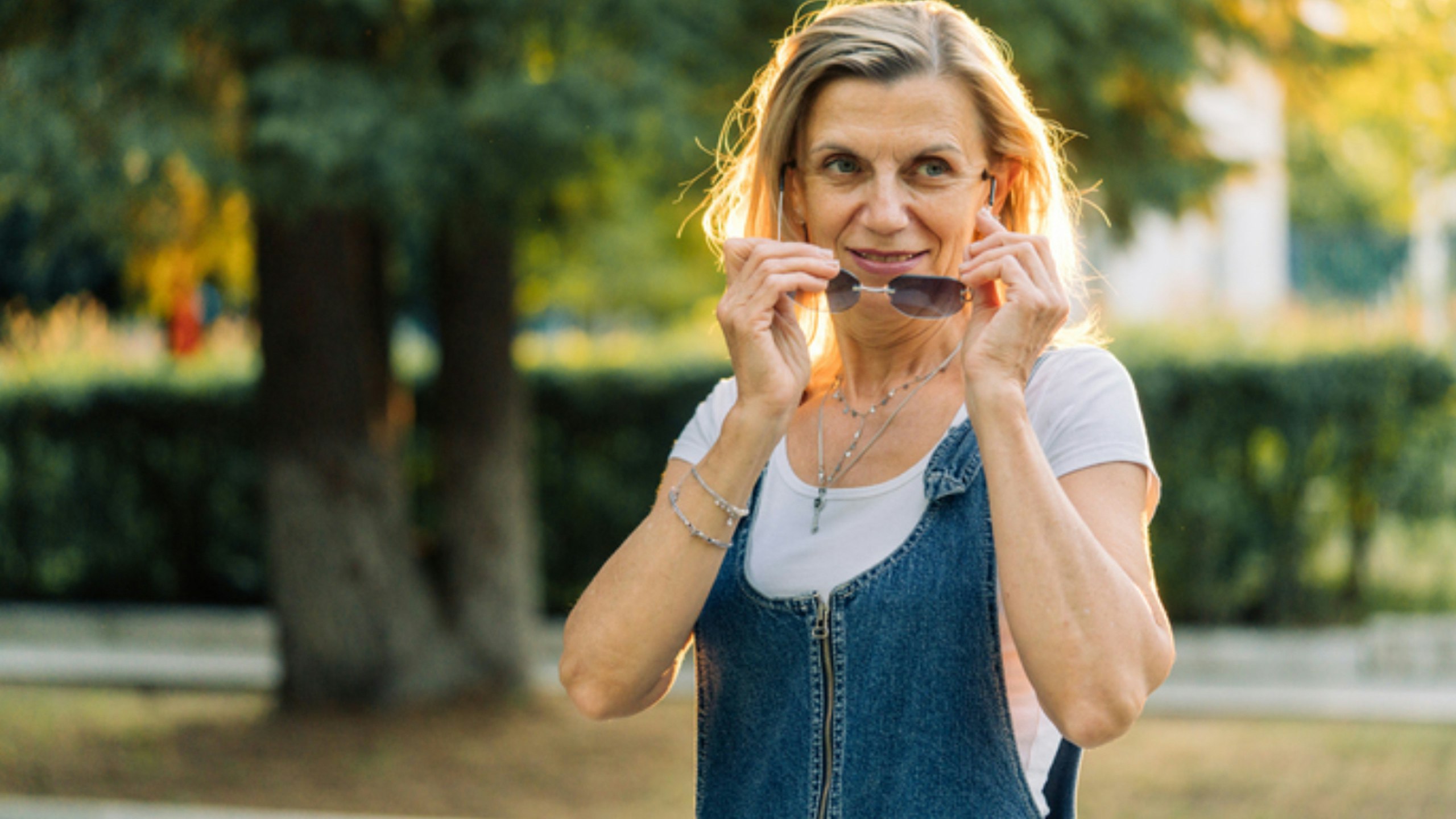 woman taking off sunglasses