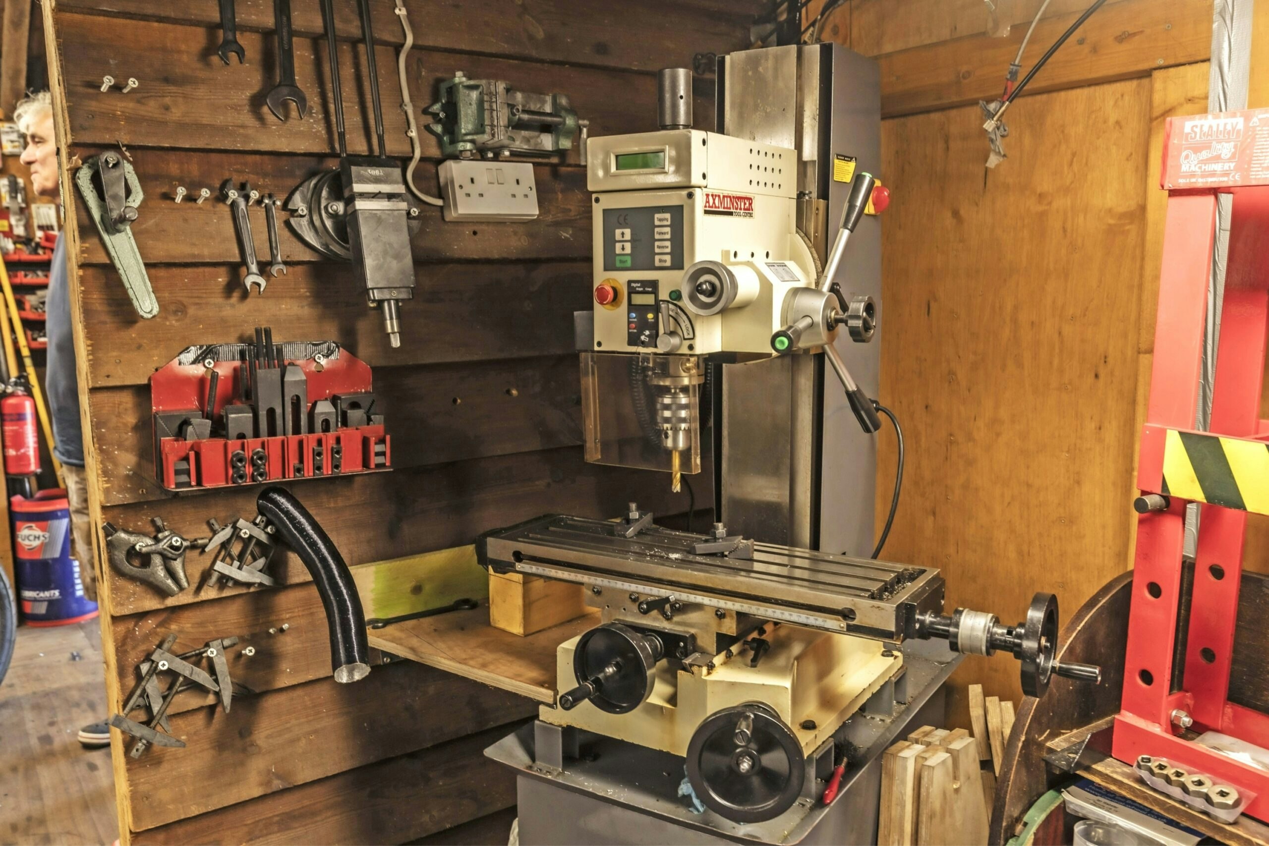 Close-up of a milling machine and workshop tools inside a home motorcycle workshop