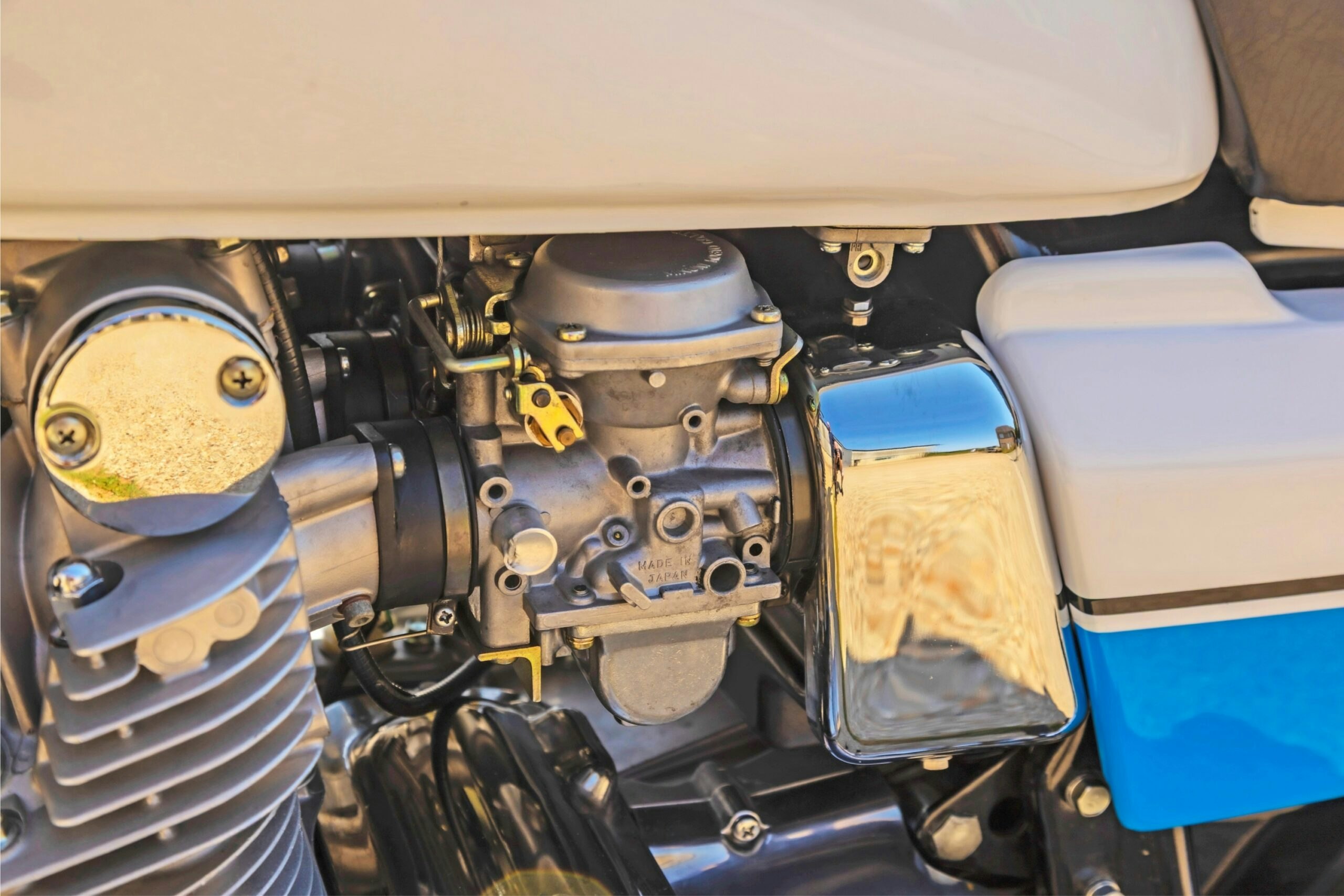 Close-up of the Suzuki GS1000S carburettor and engine beneath the fuel tank