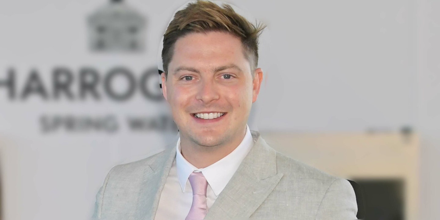 Dr Alex George from Love Island 2018 i 2022 smiling in a light grey suit