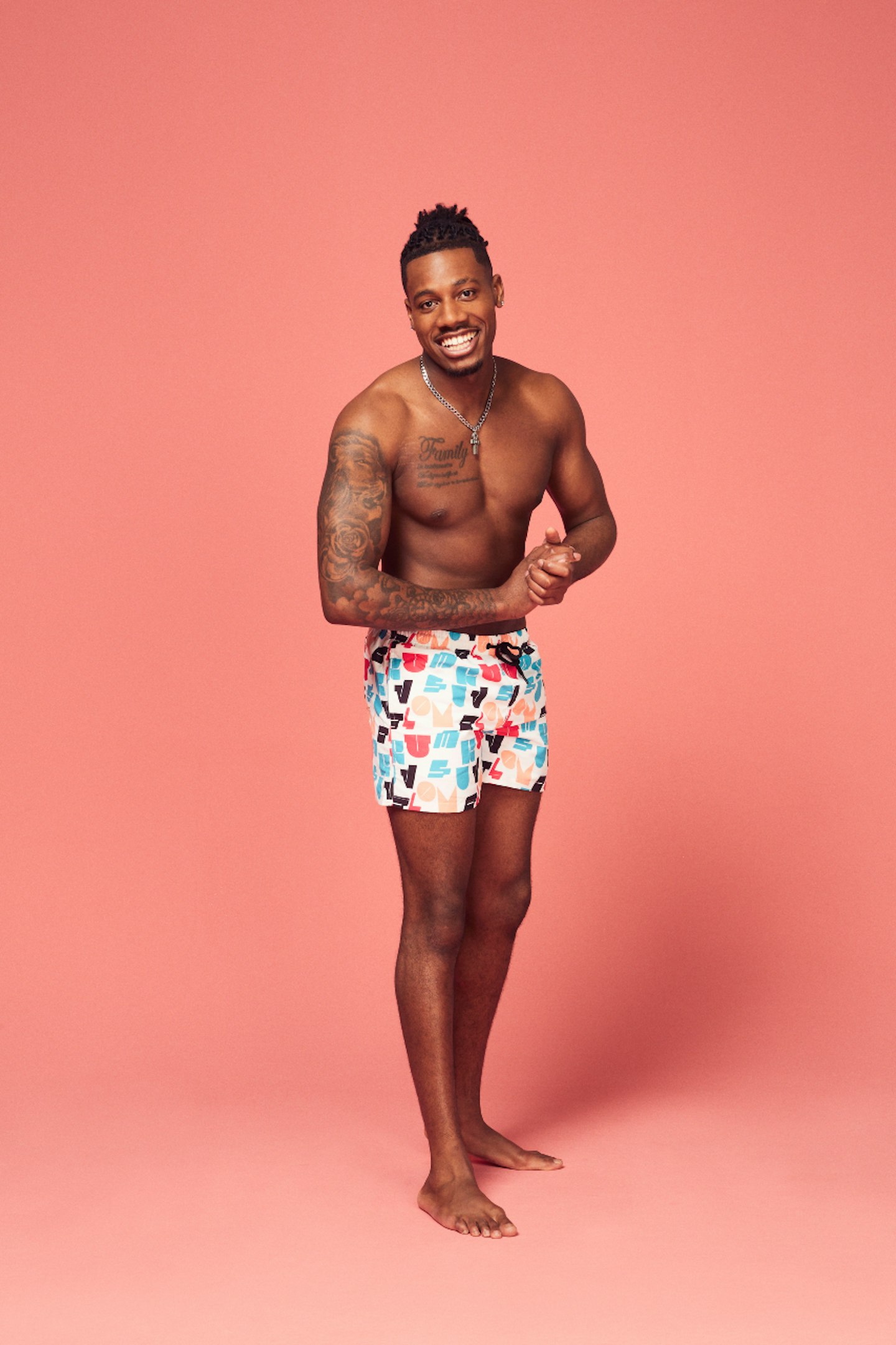 Love Island's Shaq Muhammad posing in front of a pink background