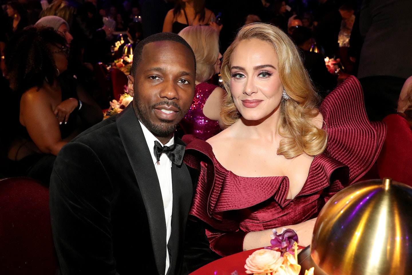 Rich Paul and Adele sitting at a table in formal clothes