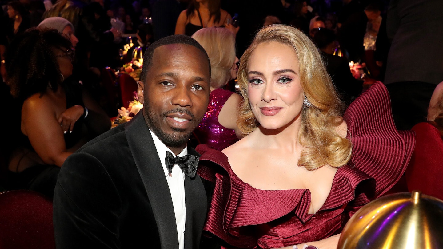 Rich Paul and Adele sitting at a table in formal clothes