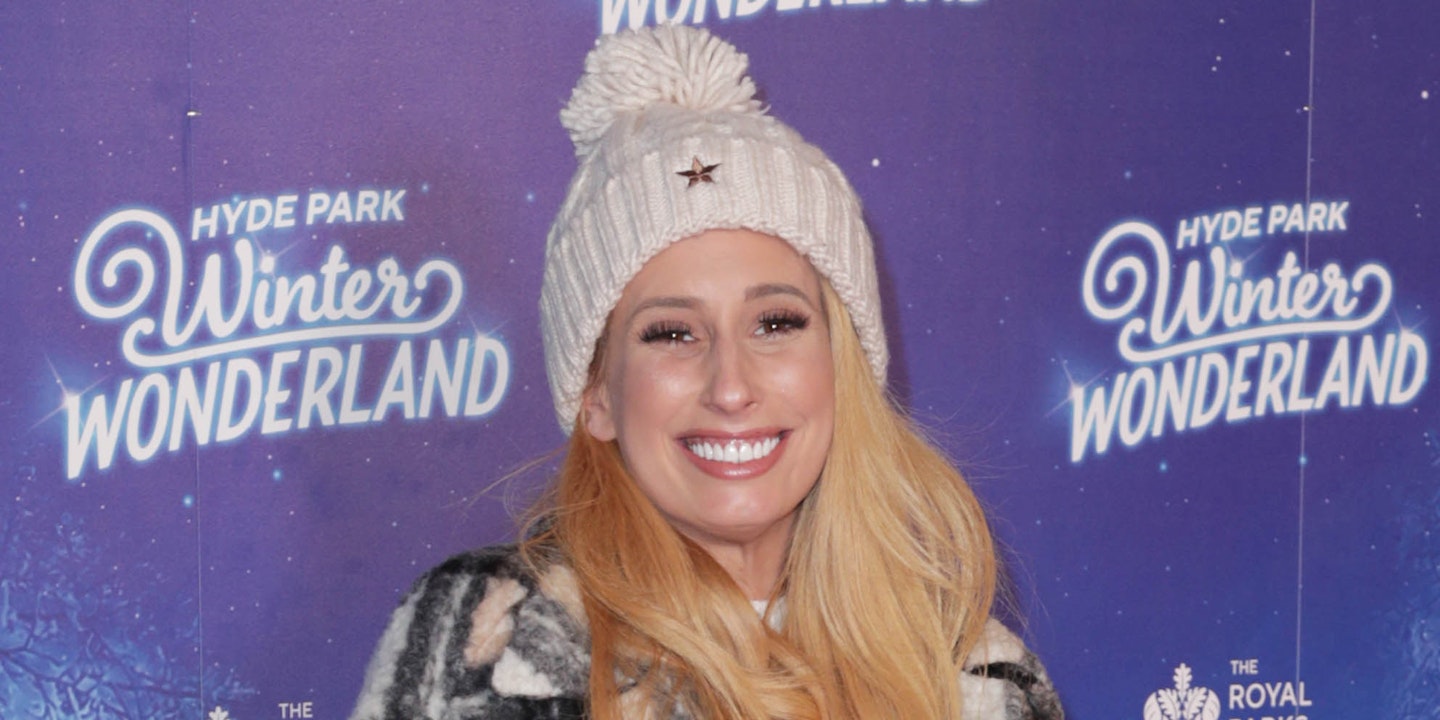 Stacey Solomon smiles wearing a white bobble hat