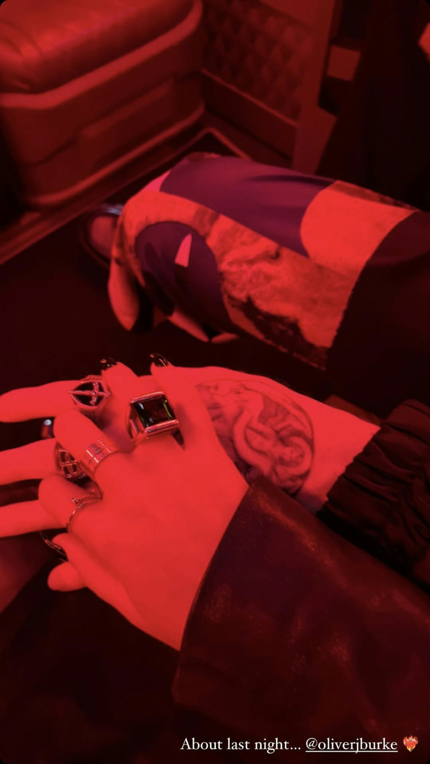 Megan Mckenna and her boyfried's hands in red lighting