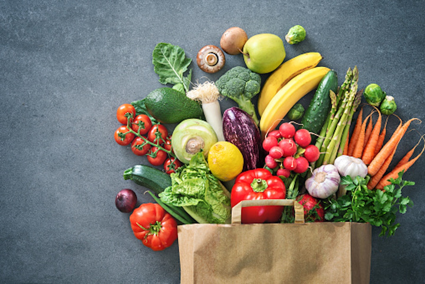 Healthy fruit and veg spilling out of a shopping bag