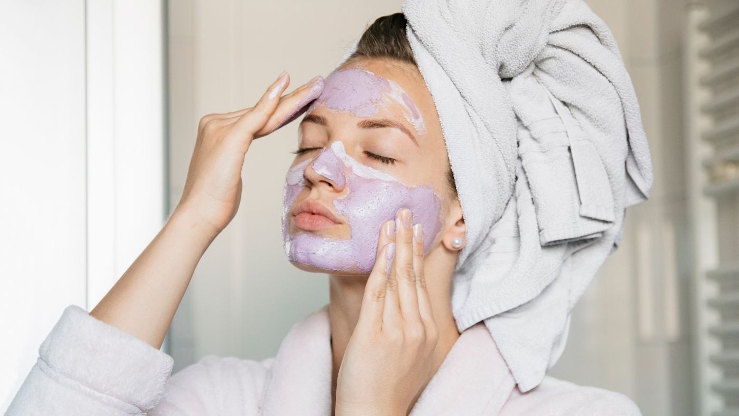 Lady putting on purple face mask