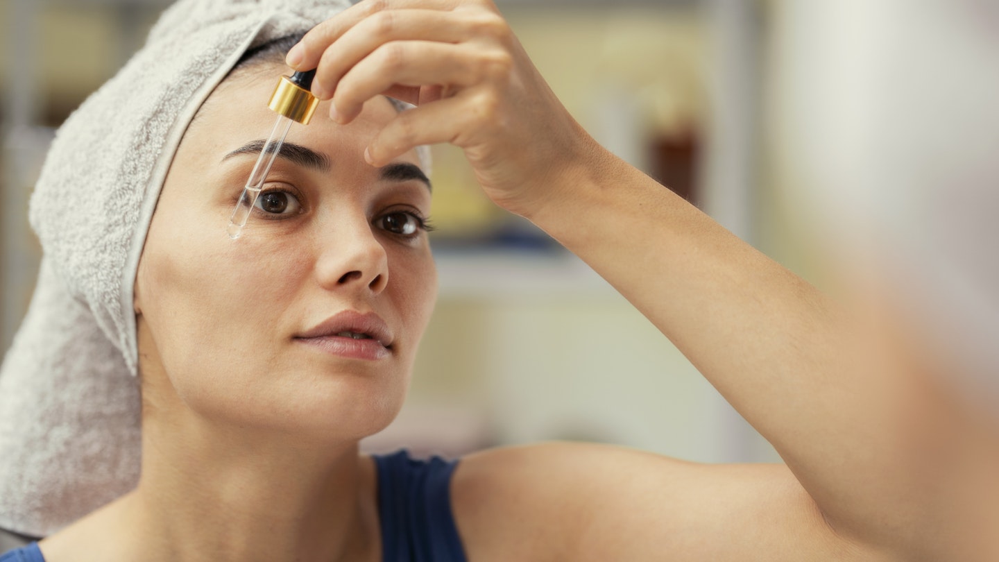 Lady applying serum to face