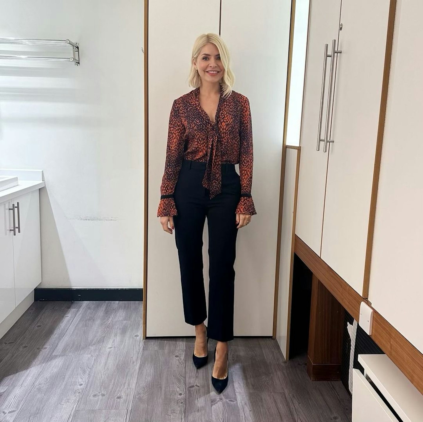 holly willoughby wearing an animal print blouse and black trousers