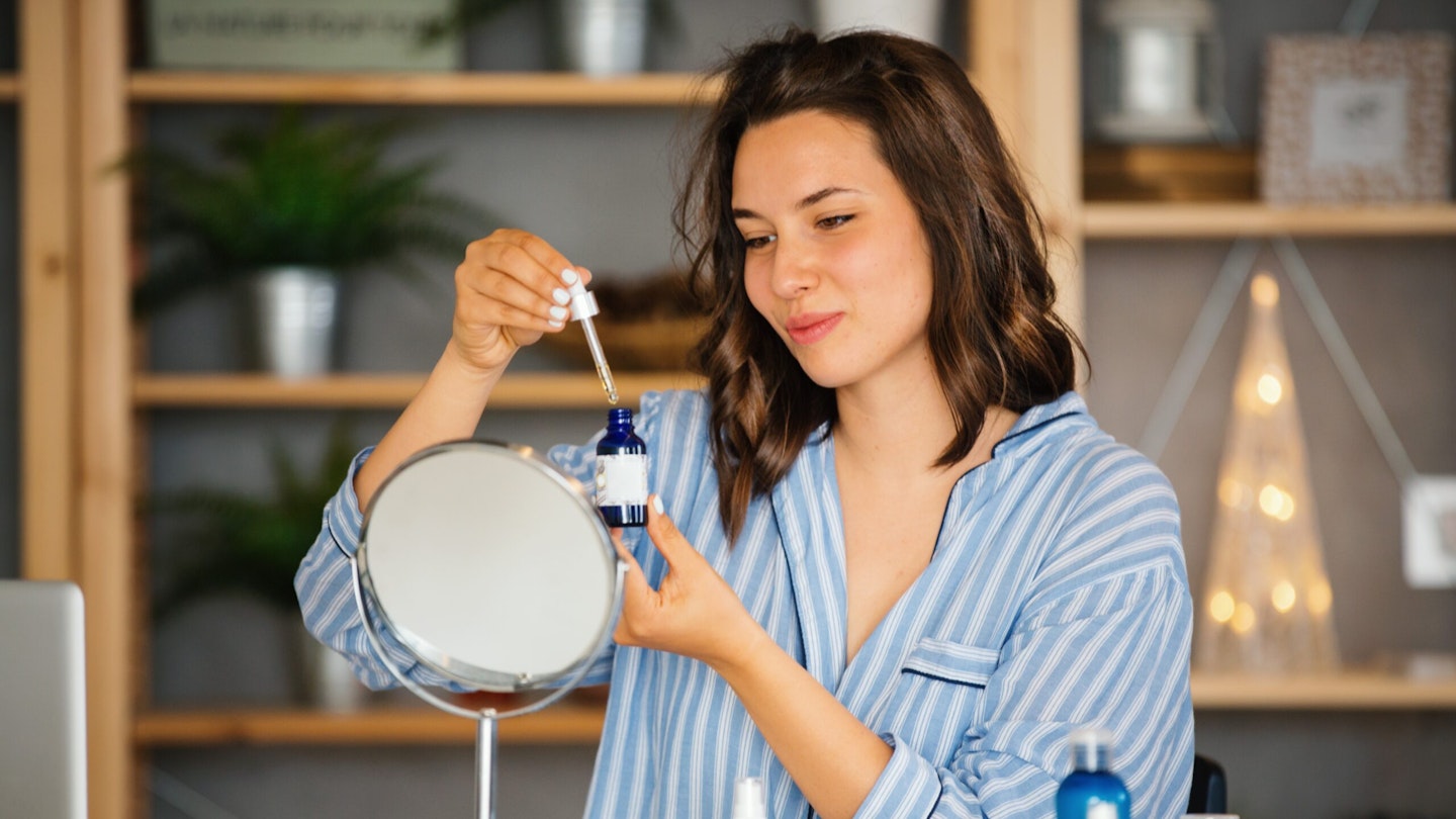 woman looking at serum bottles.