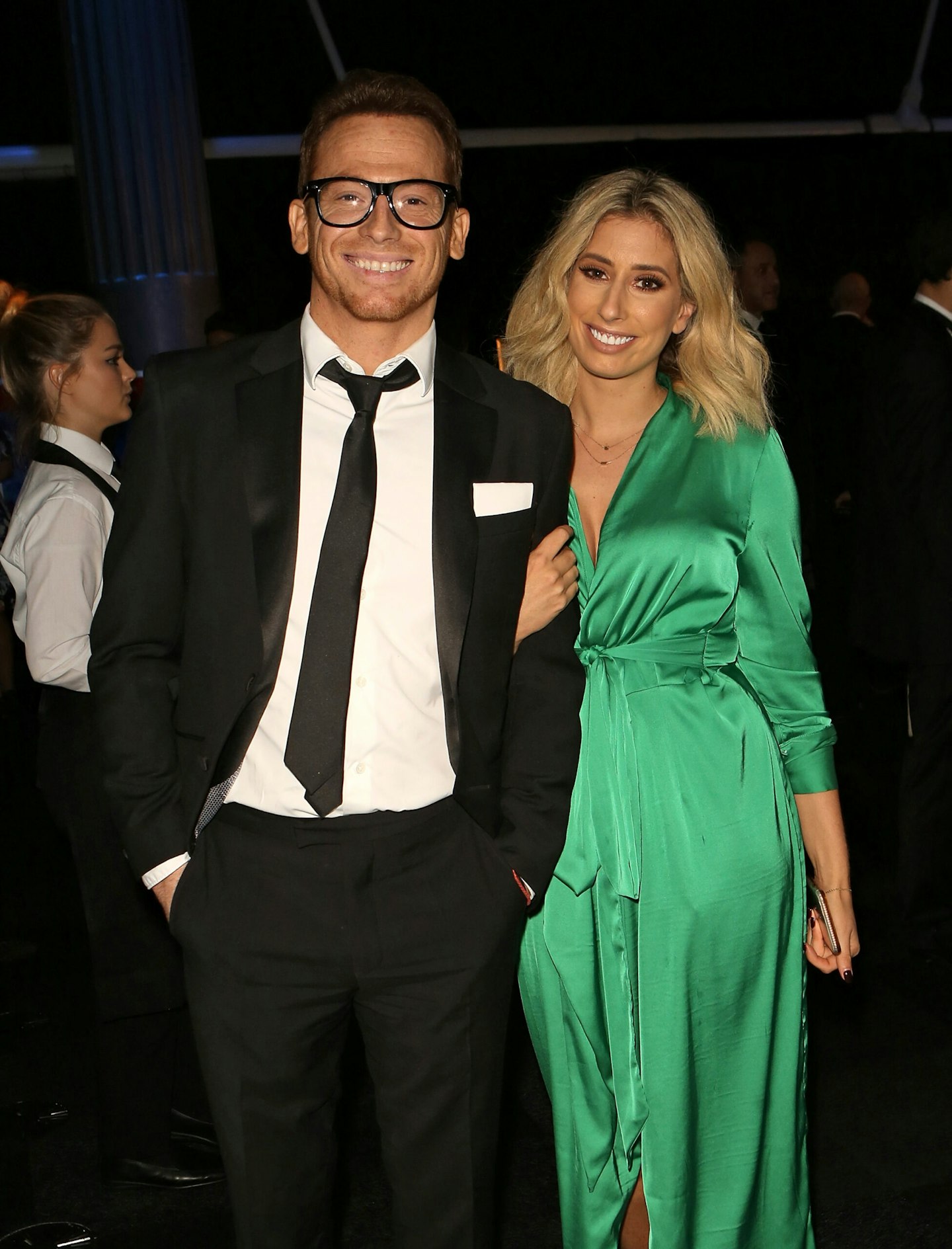 joe swash wearing a black suit and stacey solomon wearing a green satin dress together