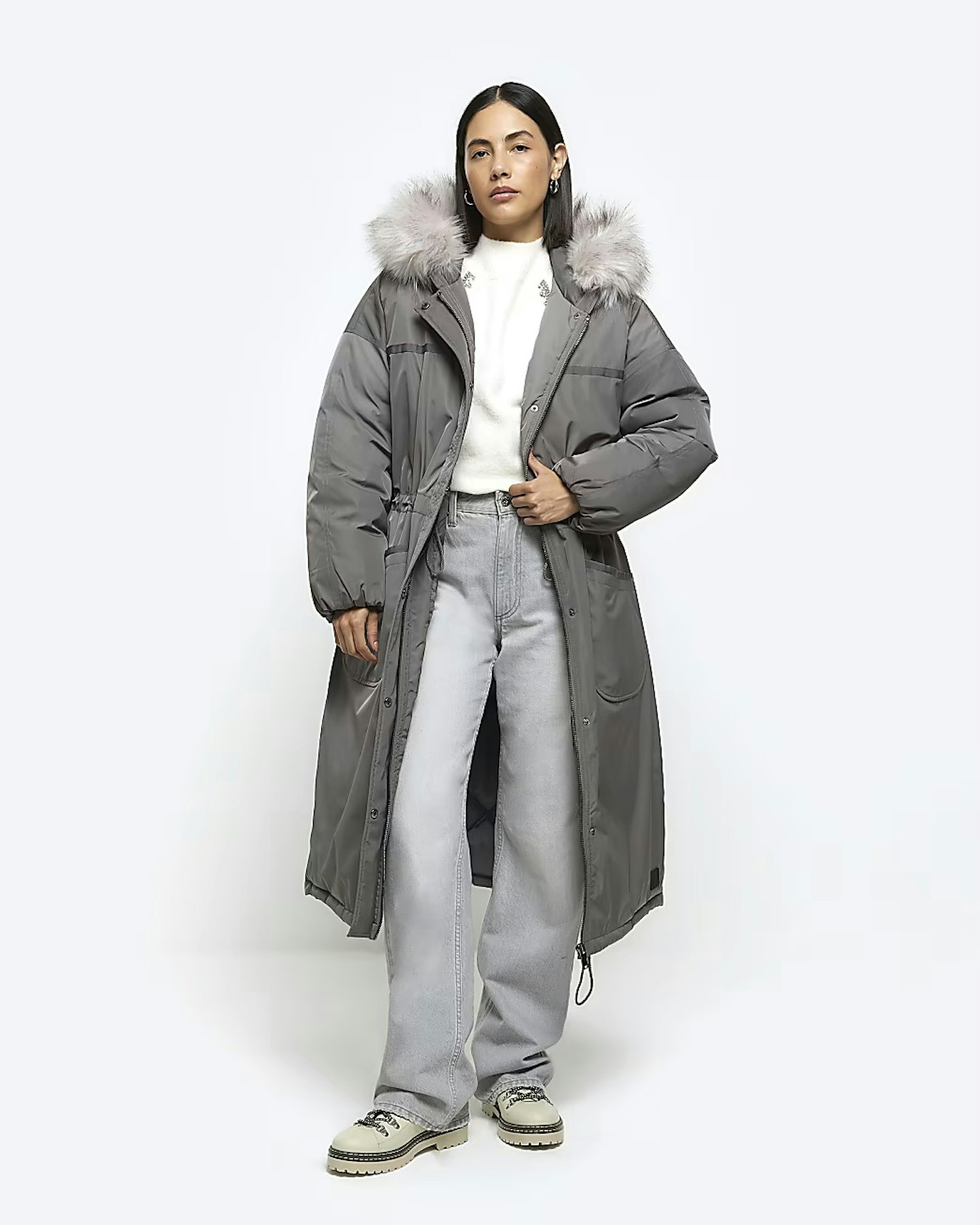 Model wearing grey longline puffer coat with faux-fur hood